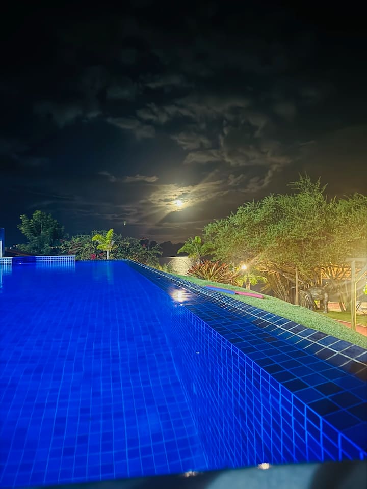 Piscina iluminada sob a lua cheia