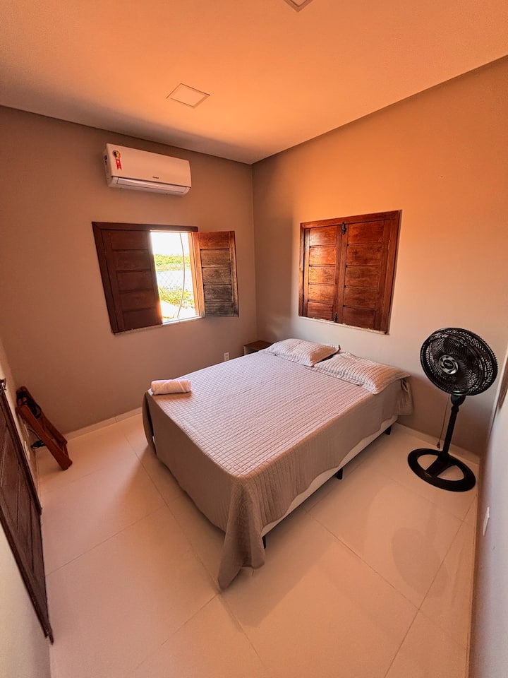 Quarto com cama de casal, ventilador e ar-condicionado