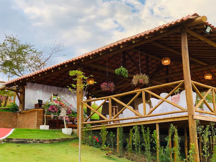 Quiosque gourmet coberto de telhas, cercado de jardim