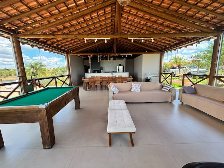 Sala com mesa de sinuca e sofás